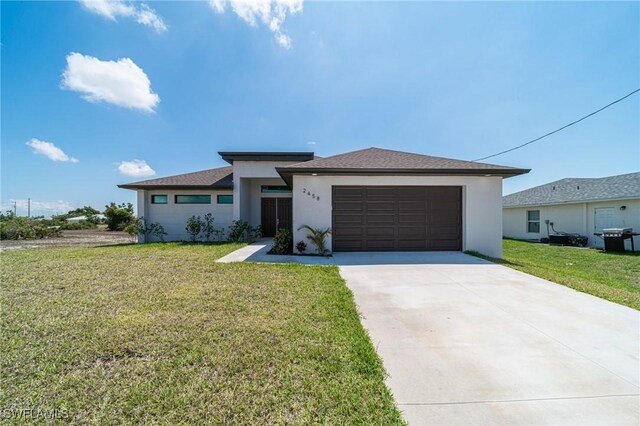 2458 NW 21st Ter, Cape Coral, FL 33993 - prairie-style house with stucco siding, a garage, concrete driveway, and a front yard