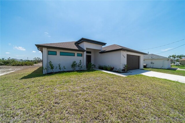 2458 NW 21st Ter, Cape Coral, FL 33993 - prairie-style home with concrete driveway, a front lawn, a garage, and stucco siding