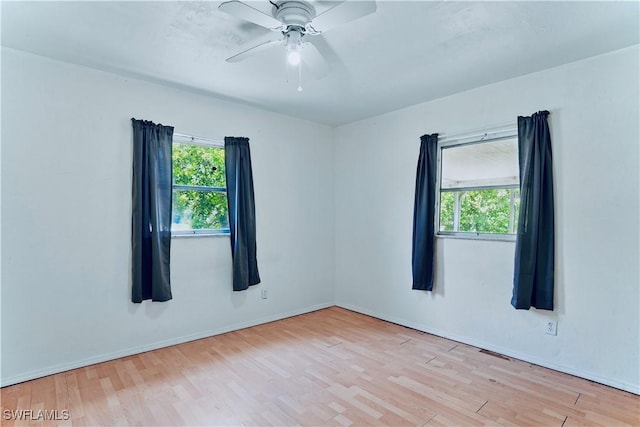 1201 E 15th St, Lehigh Acres, FL 33972 - unfurnished room with healthy amount of natural light, wood finished floors, and a ceiling fan