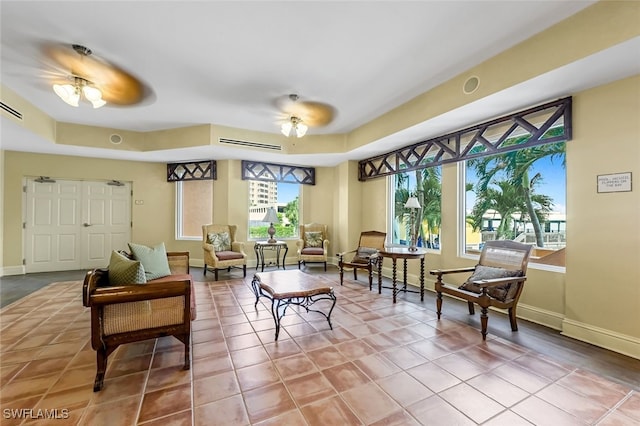8771 Estero Blvd Unit 807, Fort Myers Beach, FL 33931 - tiled living area featuring a tray ceiling, baseboards, and a ceiling fan