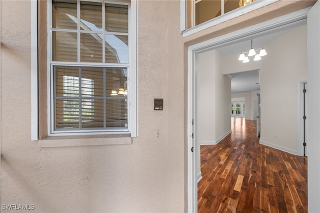 14221 Patty Berg Dr, Fort Myers, FL 33919 - corridor featuring wood finished floors, a textured wall, baseboards, and a chandelier