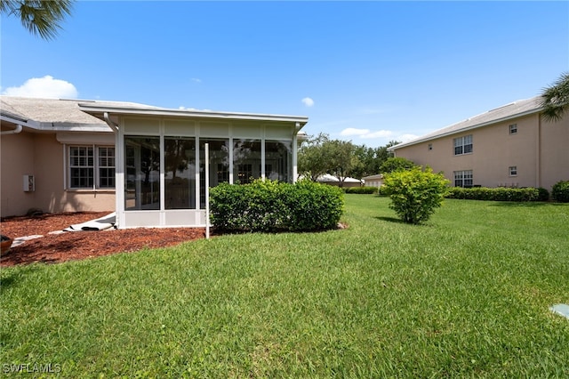 14221 Patty Berg Dr, Fort Myers, FL 33919 - back of house featuring a sunroom, a lawn, and stucco siding
