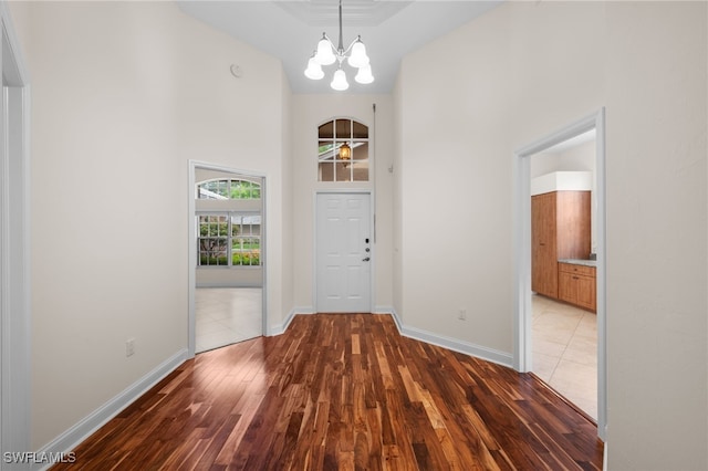 14221 Patty Berg Dr, Fort Myers, FL 33919 - entryway featuring a towering ceiling, light wood-style flooring, a chandelier, and baseboards