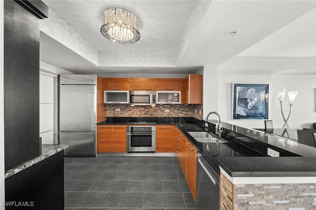 3000 Oasis Grand Blvd Unit 2103, Fort Myers, FL 33916 - kitchen with stainless steel appliances, brown cabinets, a raised ceiling, and a peninsula
