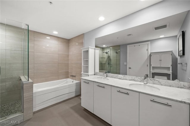 3000 Oasis Grand Blvd Unit 2103, Fort Myers, FL 33916 - bathroom featuring a garden tub, double vanity, a shower stall, tile patterned flooring, and recessed lighting