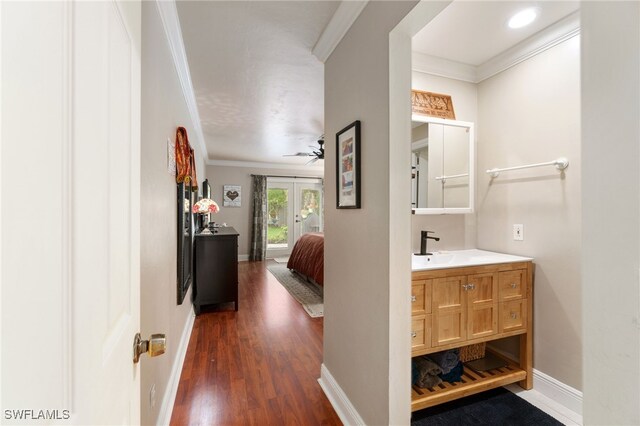955 Hidden Terrace Rd, Naples, FL 34104 - bathroom with crown molding, vanity, wood finished floors, a ceiling fan, and baseboards