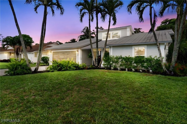 955 Hidden Terrace Rd, Naples, FL 34104 - mid-century home with stucco siding, an attached garage, a front yard, and metal roof