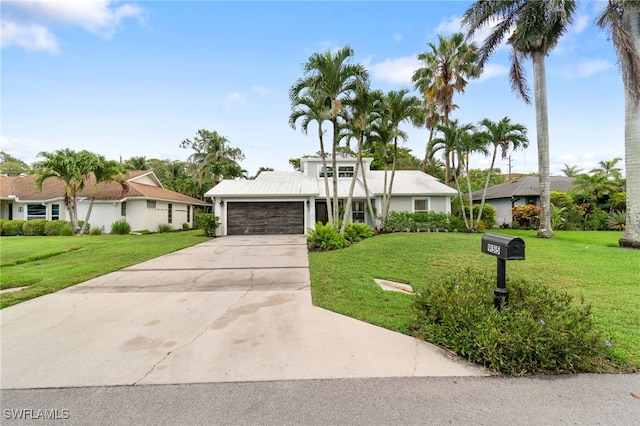 955 Hidden Terrace Rd, Naples, FL 34104 - mid-century home featuring an attached garage, driveway, and a front lawn