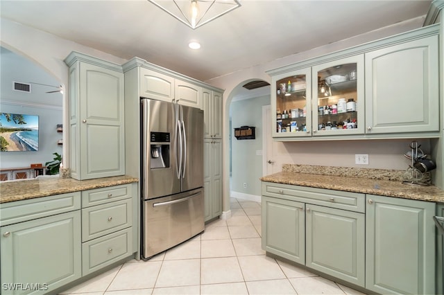 955 Hidden Terrace Rd, Naples, FL 34104 - kitchen with stainless steel fridge, arched walkways, light tile patterned floors, glass insert cabinets, and light stone counters