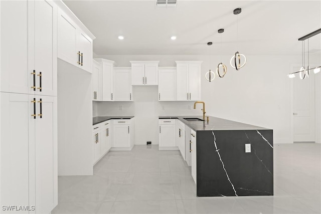1015 Gerald Ave, Lehigh Acres, FL 33936 - kitchen with a sink, white cabinets, recessed lighting, decorative light fixtures, and dark countertops