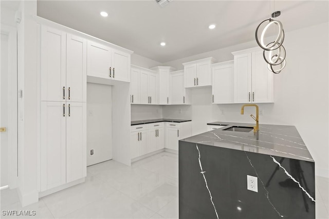 1015 Gerald Ave, Lehigh Acres, FL 33936 - kitchen with a sink, recessed lighting, white cabinetry, pendant lighting, and dark stone countertops