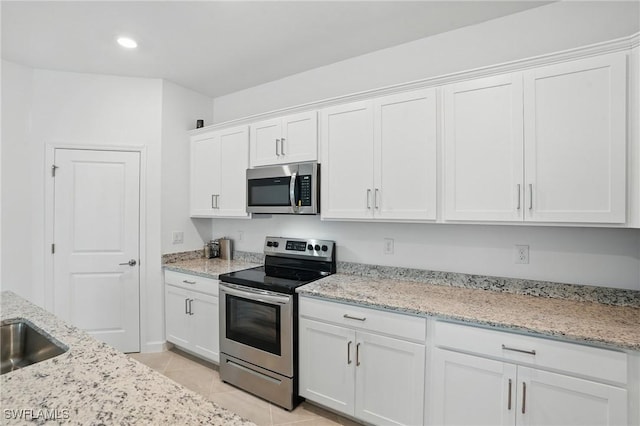 13952 Hunter Oak Dr, Fort Myers, FL 33913 - kitchen with appliances with stainless steel finishes, white cabinetry, light tile patterned flooring, light stone countertops, and recessed lighting