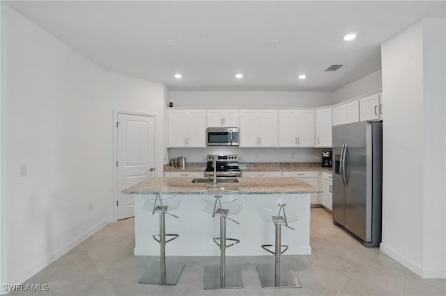 13952 Hunter Oak Dr, Fort Myers, FL 33913 - kitchen featuring appliances with stainless steel finishes, a kitchen island with sink, baseboards, white cabinets, and recessed lighting