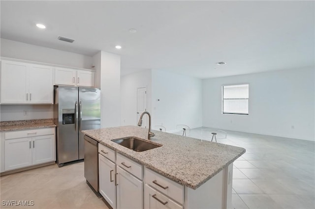 13952 Hunter Oak Dr, Fort Myers, FL 33913 - kitchen featuring stainless steel appliances, a sink, white cabinets, a kitchen island with sink, and light tile patterned floors