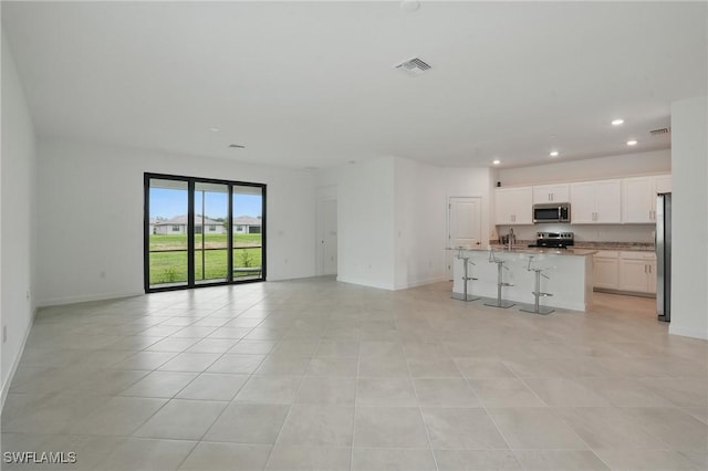 13952 Hunter Oak Dr, Fort Myers, FL 33913 - unfurnished living room with recessed lighting, baseboards, a sink, and light tile patterned floors