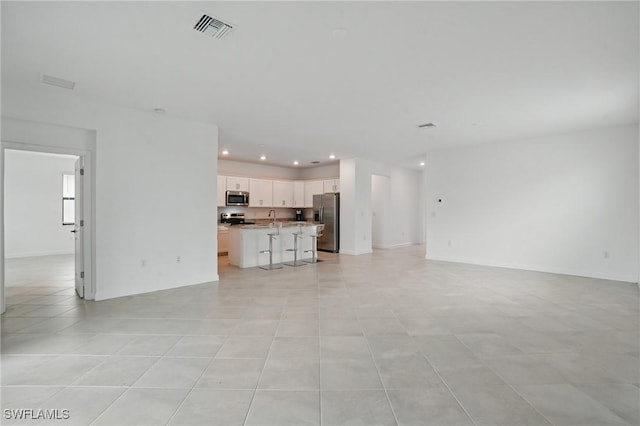 13952 Hunter Oak Dr, Fort Myers, FL 33913 - unfurnished living room with recessed lighting, light tile patterned floors, and a sink