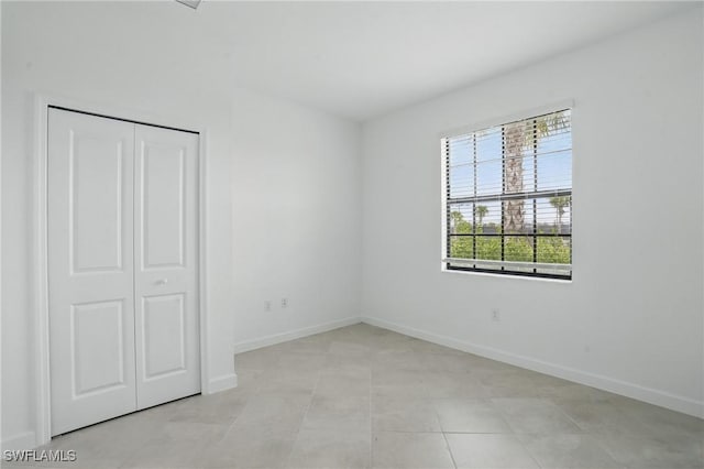 13952 Hunter Oak Dr, Fort Myers, FL 33913 - unfurnished bedroom with baseboards, a closet, and light tile patterned floors