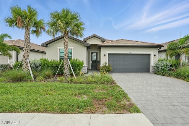 13952 Hunter Oak Dr, Fort Myers, FL 33913 - single story home with an attached garage, decorative driveway, stucco siding, and a front yard