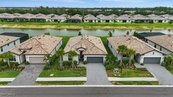 13952 Hunter Oak Dr, Fort Myers, FL 33913 - view of front of house featuring a residential view, a water view, decorative driveway, and an attached garage
