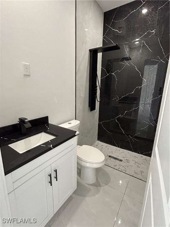 2815 4th St SW, Lehigh Acres, FL 33976 - full bathroom featuring a marble finish shower, vanity, marble finish flooring, and toilet