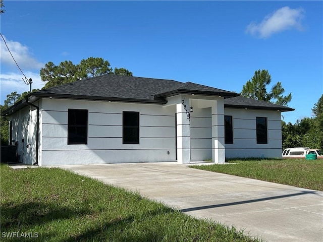 2815 4th St SW, Lehigh Acres, FL 33976 - view of front facade featuring a front lawn, stucco siding, and a shingled roof