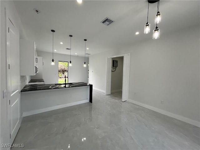 2815 4th St SW, Lehigh Acres, FL 33976 - kitchen featuring white cabinets, dark countertops, baseboards, a peninsula, and recessed lighting