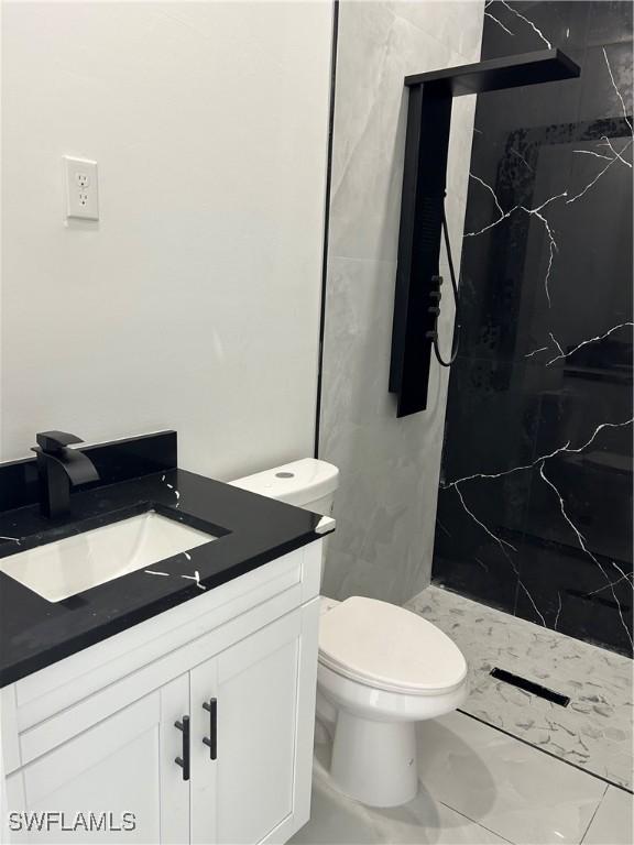 2815 4th St SW, Lehigh Acres, FL 33976 - full bath with a marble finish shower, vanity, marble finish floors, and toilet