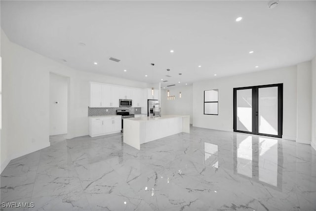 3034 Chiquita Blvd N, Cape Coral, FL 33993 - kitchen featuring appliances with stainless steel finishes, light marble finish floors, white cabinetry, open floor plan, and recessed lighting