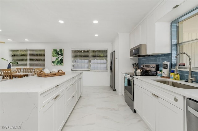 5127 SW 3rd Ave, Cape Coral, FL 33914 - kitchen featuring appliances with stainless steel finishes, a sink, recessed lighting, white cabinets, and a kitchen island