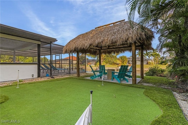 5127 SW 3rd Ave, Cape Coral, FL 33914 - view of yard featuring an area to practice putting, a patio, and a lanai
