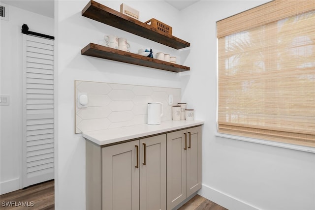 3030 Binnacle Dr Unit 206, Naples, FL 34103 - bar with a barn door, dark wood-type flooring, decorative backsplash, and baseboards