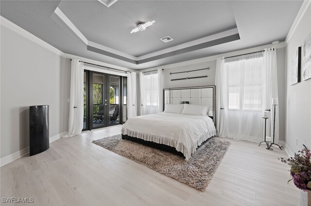 4654 Kensington Cir, Naples, FL 34119 - bedroom featuring french doors, a tray ceiling, access to exterior, wood finished floors, and baseboards