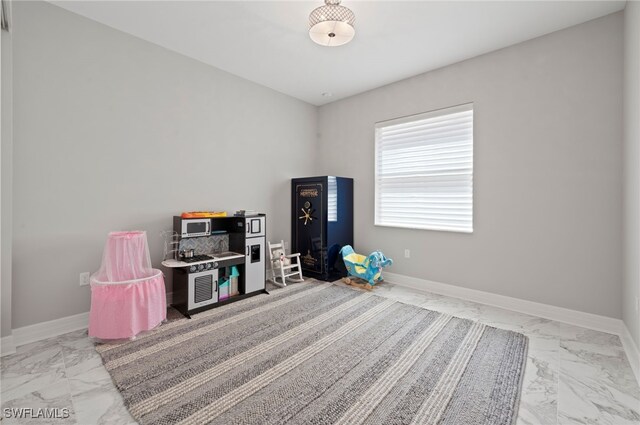 4654 Kensington Cir, Naples, FL 34119 - game room featuring marble look tile flooring and baseboards