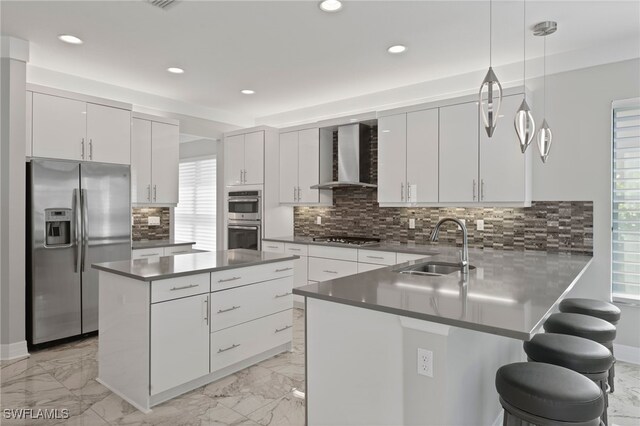 4654 Kensington Cir, Naples, FL 34119 - kitchen featuring appliances with stainless steel finishes, wall chimney range hood, a sink, recessed lighting, and a peninsula