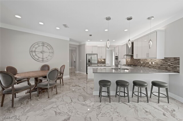 4654 Kensington Cir, Naples, FL 34119 - kitchen featuring stainless steel appliances, a sink, a peninsula, wall chimney exhaust hood, and recessed lighting