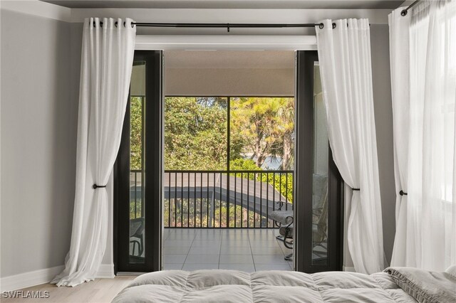 4654 Kensington Cir, Naples, FL 34119 - bedroom featuring baseboards, access to exterior, and tile patterned floors