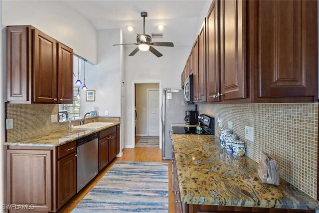 608 SW 43rd Ter, Cape Coral, FL 33914 - kitchen with appliances with stainless steel finishes, ceiling fan, backsplash, light wood-style floors, and light stone countertops
