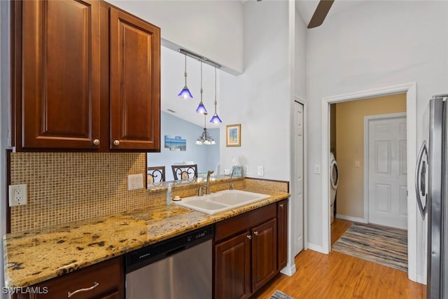 608 SW 43rd Ter, Cape Coral, FL 33914 - kitchen with appliances with stainless steel finishes, light wood-style flooring, backsplash, hanging light fixtures, and light stone counters
