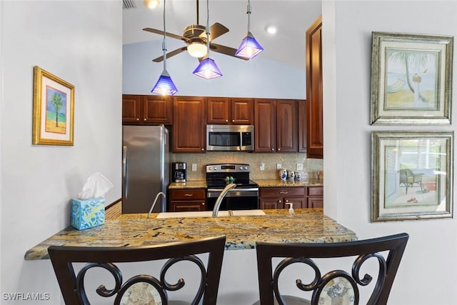 608 SW 43rd Ter, Cape Coral, FL 33914 - kitchen with appliances with stainless steel finishes, ceiling fan, a breakfast bar area, a peninsula, and backsplash