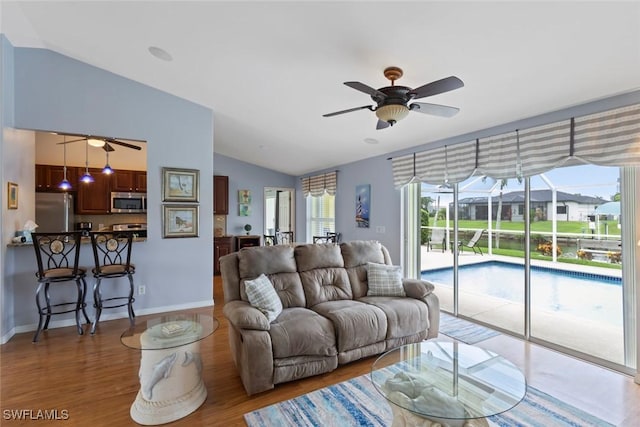 608 SW 43rd Ter, Cape Coral, FL 33914 - living room featuring vaulted ceiling, a ceiling fan, and wood finished floors