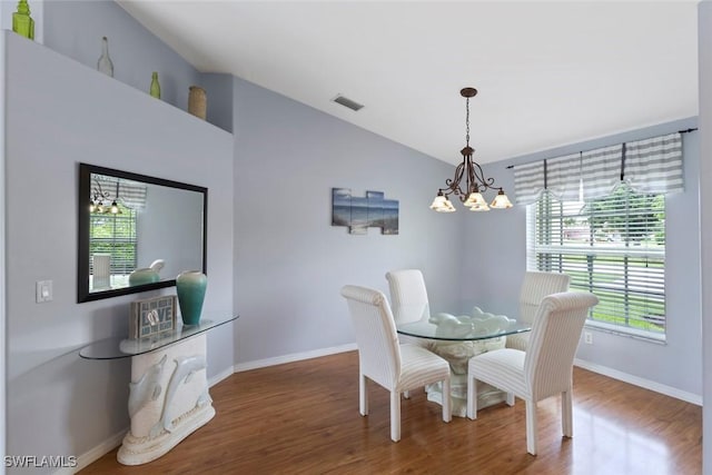 608 SW 43rd Ter, Cape Coral, FL 33914 - dining space with a chandelier, vaulted ceiling, and wood finished floors