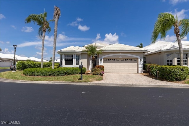 19372 Silver Oak Dr, Estero, FL 33967 - view of front of house with a garage, a tiled roof, driveway, and stucco siding