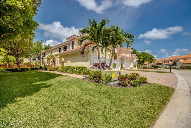 5912 Tarpon Gardens Cir Unit 201, Cape Coral, FL 33914 - view of front of home featuring stucco siding, a front yard, decorative driveway, and a garage