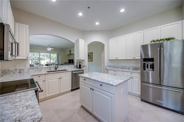 5912 Tarpon Gardens Cir Unit 201, Cape Coral, FL 33914 - kitchen with stainless steel appliances, a sink, arched walkways, recessed lighting, and a center island