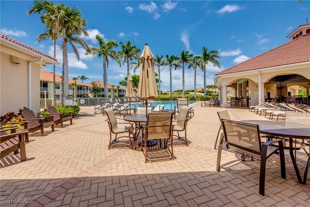 5912 Tarpon Gardens Cir Unit 201, Cape Coral, FL 33914 - view of patio with outdoor dining area and a community pool
