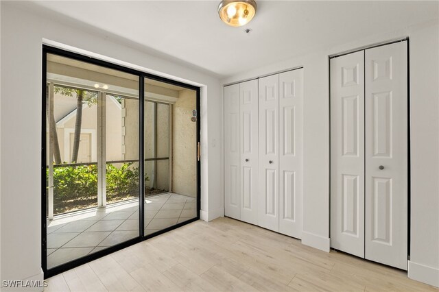16410 Kelly Cove Dr Unit 313, Fort Myers, FL 33908 - unfurnished bedroom featuring multiple closets and wood finished floors