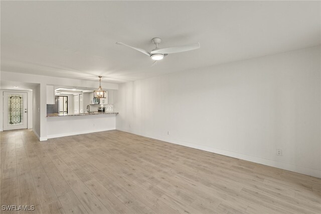 16410 Kelly Cove Dr Unit 313, Fort Myers, FL 33908 - unfurnished living room with a sink, light wood-style floors, a ceiling fan, and baseboards