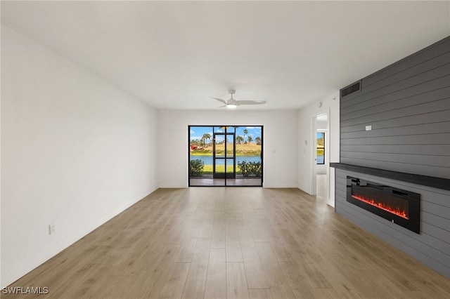 16410 Kelly Cove Dr Unit 313, Fort Myers, FL 33908 - unfurnished living room featuring a large fireplace, light wood-style floors, ceiling fan, and baseboards