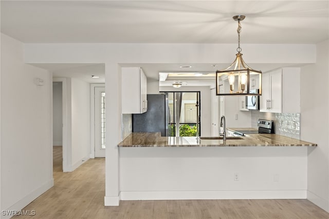 16410 Kelly Cove Dr Unit 313, Fort Myers, FL 33908 - kitchen featuring stainless steel appliances, a sink, backsplash, white cabinetry, and a peninsula