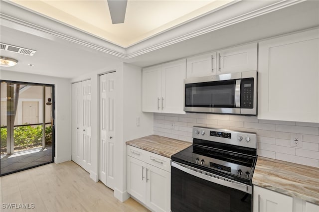 16410 Kelly Cove Dr Unit 313, Fort Myers, FL 33908 - kitchen featuring stainless steel appliances, white cabinets, decorative backsplash, and light wood finished floors